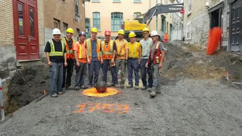Lafontaine Inc Workers pose beside the cannonball in Quebec