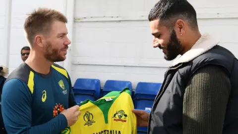 David Warner hands Jaykishan Plaha a signed Australia shirt