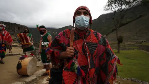 EPA A person dressed in costume prepares for the ceremony to mark the reopening of Machu Picchu