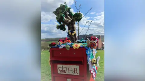 Tracey Fudge Postbox topper before it was damaged by fire in Asker Lane, Matlock, Derbyshire