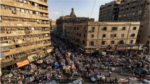 AFP Crowds on people at Ataba Square. There are old building in the frame.