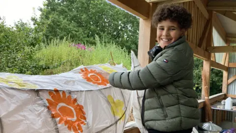 BBC A boy decorating a fox lantern
