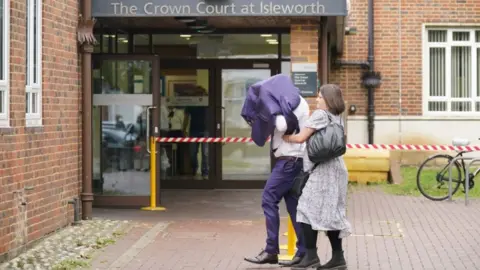 PA Media Lee Ryan arriving at Isleworth Crown Court on 28 September, with a jacket over his head.