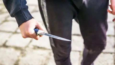 Getty Images Child carrying a knife