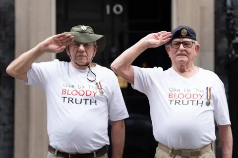 PA Media Veterans Terry Quinlan and Brian Unthank salute in front of 10 Downing Street