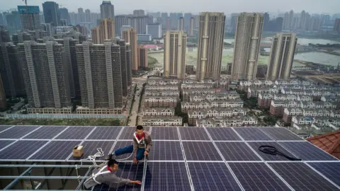 Getty Images Men work on a solar panel project in Wuhan, China.