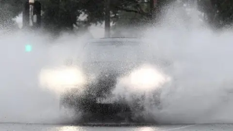 EPA A car travels drives through heavy rain in Australia