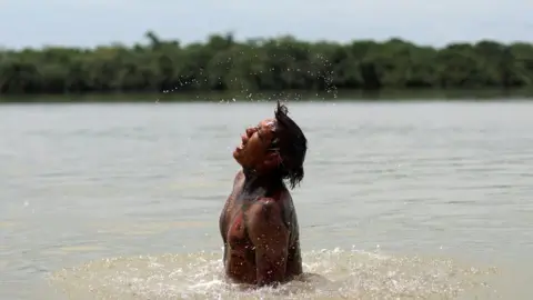 Reuters An indigenous man of Kuikuru tribe takes a bath on Xingu River