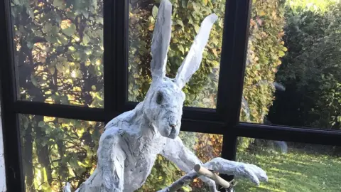 Viv Scone Sculpture of a hare on a child's scooter