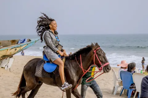 Grace Ekpu/BBC Woman riding a horse