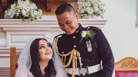 A man in military dress uniform, Tristan Manalo, standing next to a seated woman who is wearing a bridal gown, Manalo Tara