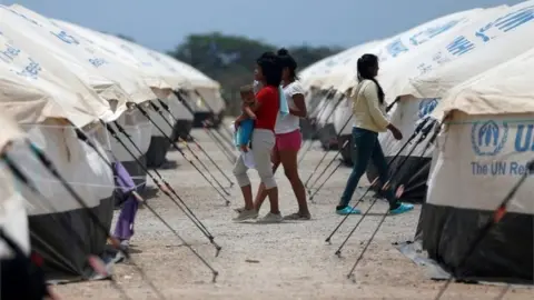 Reuters Venezuelan migrant women walk through a camp run by the UN refugee agency UNHCR in Maicao, Colombia May 7, 2019