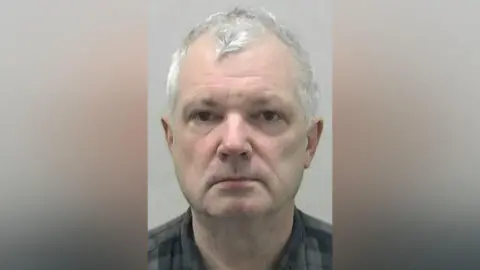 Northumbria Police Mugshot of Gardner. He is clean shaven and pale, with short white hair