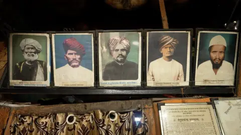 BBC/ Sharad Badhe On the wall of Faridsahab's hundred year old home are the photographs of the six family heads of the previous generations