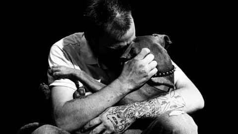 Leah Denbok This 2016 image of a homeless man and his dog was captured when Denbok glanced back after taking his photo and saw the spontaneous embrace