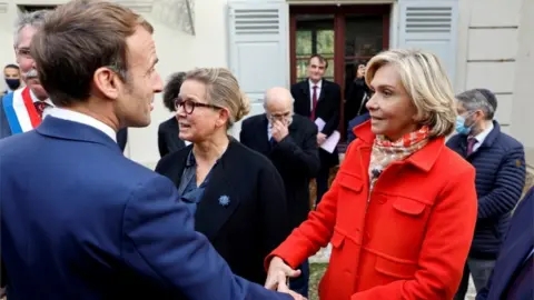 EPA French President Emmanuel Macron greets Ile de France regional president and candidate for the French right-wing Les Republicains primary election Valerie Pecresse at the Emile Zola house in Medan, near Paris, on October 26, 2021