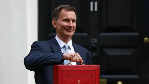 Getty Images Jeremy Hunt holding his red box outside 11 Downing Street