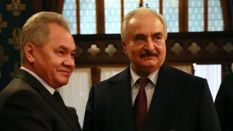 AFP Khalifa Haftar shakes hands with Russian Defence Minister Sergei Shoigu in Moscow