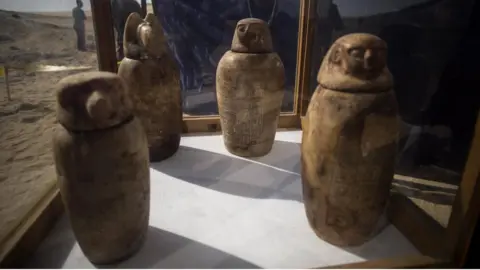 EPA Four canopic jars, made of alabaster with lids bearing the faces of the four sons of god Horus, that were unearthed are displayed at the site of an ancient Egyptian cemetery, in Minya province, 245 km south of Cairo, Egypt.