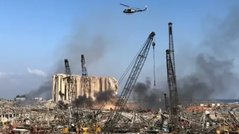 Reuters A Lebanese army helicopter flies over the site of Tuesday's blast in Beirut's port area, Lebanon August 5, 2020