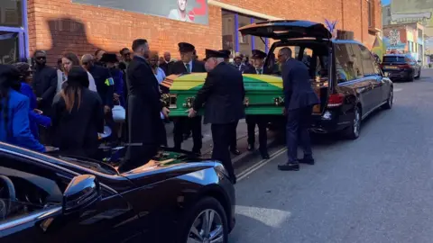 Roy's coffin being carried into the service