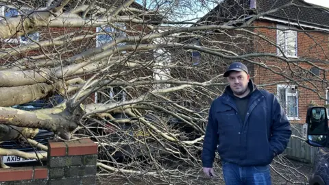 Matt Marvel/BBC Michael Burgess standing next to a fallen tree