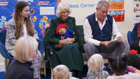 Arthur Edwards/The Sun Camilla seated with Paddington film cast members Hugh Bonneville (right) and Madeleine Harris (left)