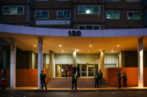 Getty Images Police outside flats in Melbourne, 4 July