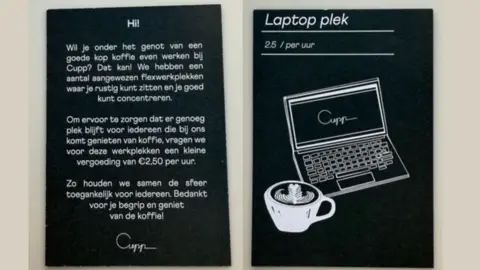 Steff Rees Two black signs with white writing in Dutch and an image of a laptop and a cup of coffee informing customers of the charge