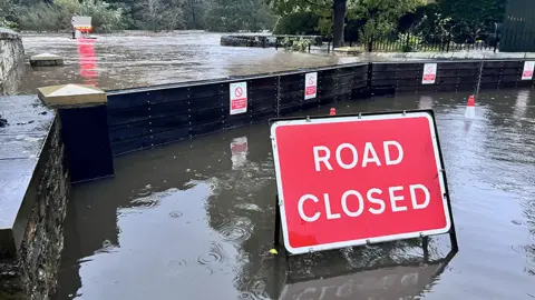 Flood gates with road closed sign