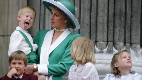 Tim Graham Young Prince Harry sticking his tongue out in the balcony, while being held by his mother Princess Diana