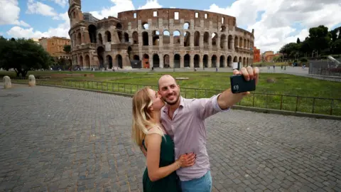 Reuters A couple take a picture outside the Colosseum