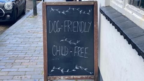A chalk sign saying "dog-friendly, child-free"