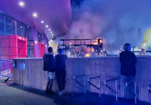 People watch fire crews tackle a bus fire at Burnley bus station