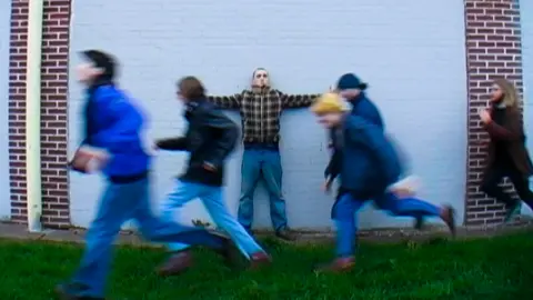 Trans Siberian Express Picture is an album cover showing a man standing in front of a white brick wall and five men running past him.