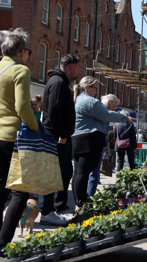 People queue up for a market stool.