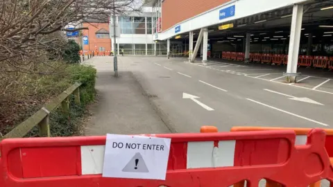 A barrier blocking the access road into the supermarket car park