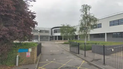Google A general view picture of the school, a two-storey building with black gates surrounding it.