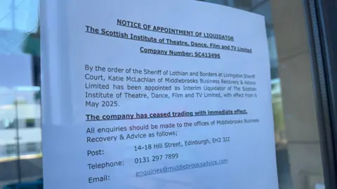 A liquidation notice stuck to the door of the Scottish Institute of Theatre, Dance, Film and Television.