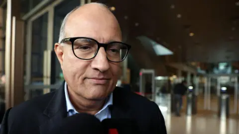 Getty Images Close-up shot of Iswaran wearing black spectacles outside Singapore's court