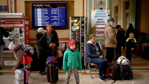 Reuters Ukrainian refugees waiting for a train in Poland in April