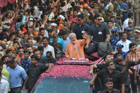 Getty Images Prime Minister Narendra Modi waves to public during road show at Assi Ghat road on April 25, 2019 in Varanasi, India.