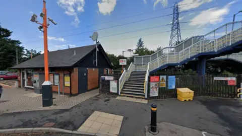 The exterior of Canley railway station, with a small red-brick building next to a large set of steps.