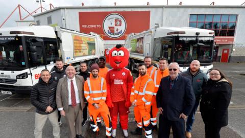 Councillors Bob Noyce, third from right, and Michael Jones, third from left, with Reggie the Red, Biffa, council and Crawley Town FC staff.