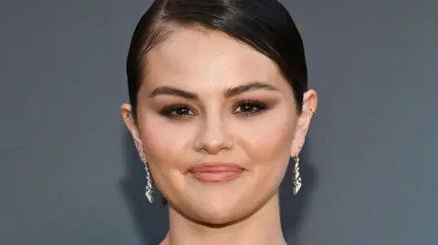 Getty Images Selena Gomez head shot, wearing drop diamond earrings