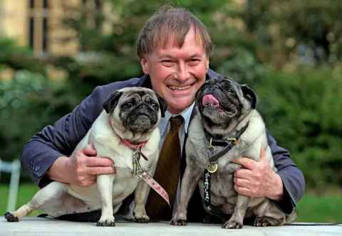 Geoff Caddick Conservative MP David Amess with his pugs, Lily and Boat at the Westminster Dog of the Year competition at Victoria Tower Gardens in London in October 2013