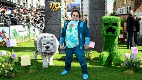Getty Images Jack Black doing publicity for A Minecraft Movie, with large figures from the film