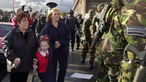 Pacemaker Frightened schoolgirls needed armed police escorts to walk to Holy Cross primary school in 2001