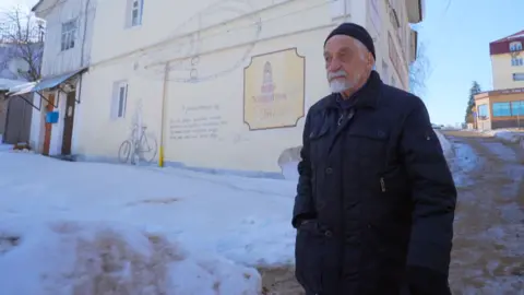 BBC Vladimir Ovchinnikov walks near his graffiti