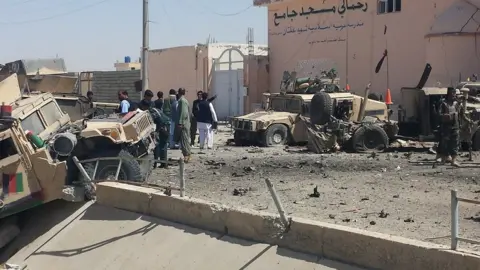 Getty Images Afghan security personnel inspect the site of a suicide attack near the main police headquarters in Lashkar Gah, capital of Helmand province, 23 August 2017